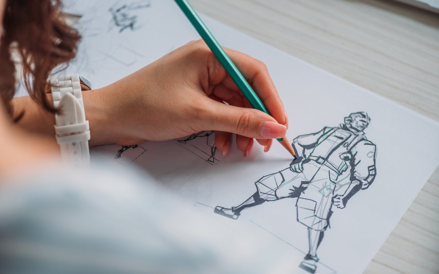 A hand sketching a character design in pencil, refining the figure's pose and gear